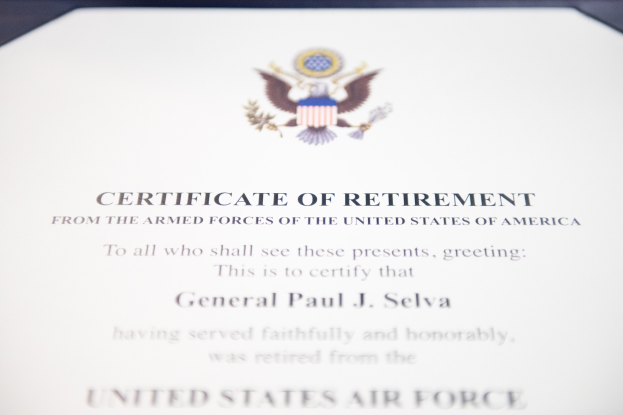 Rahmenurkunde zur Verabschiedung von der United States Air Force mit blauem Rand, die ein schwarzes Textfeld und ein zentrales Schild-Logo mit einem Stern, einem Lorbeerkranz und einer 'Verabschiedung'-Banderole zeigt.