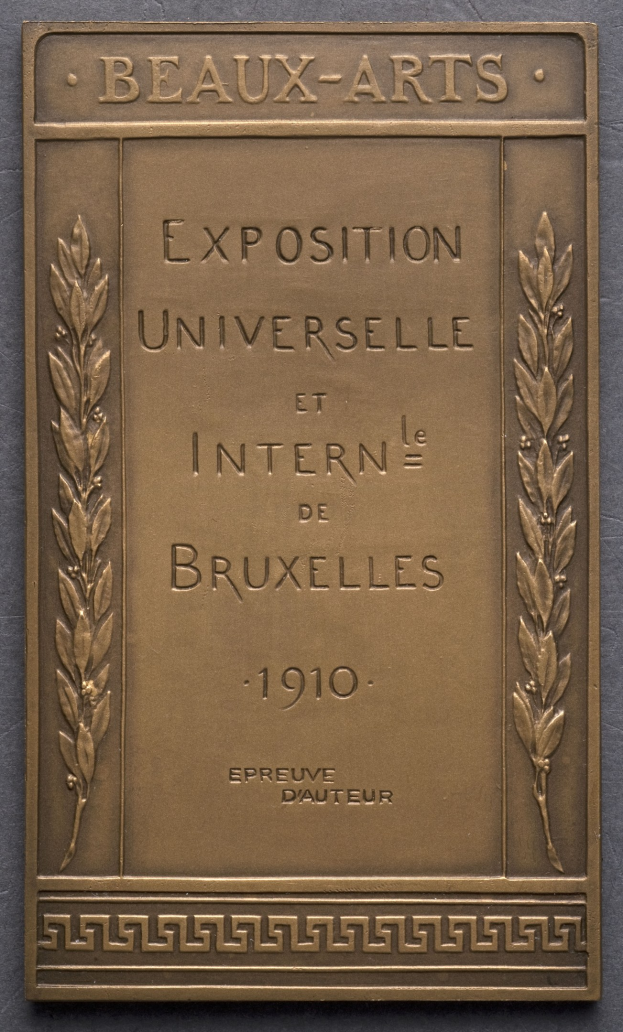 Bronzetafel mit der Inschrift "Exposition Universelle et Internationale de Bruxelles 1910" in fetter Schrift, umgeben von einem dekorativen Rahmen, mit einem Glanzfinish.