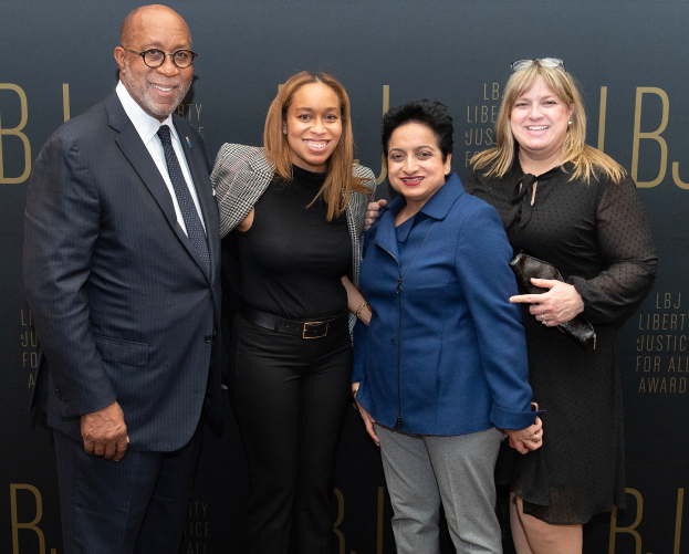 Vier Personen auf einem roten Teppich bei den 'Liberty Justice for All Awards', die für ein Foto posen