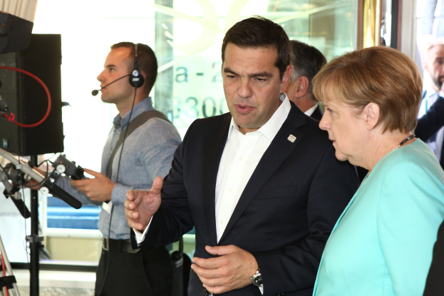 Bundeskanzlerin Angela Merkel und Joachim Gauck vor einer Glaswand mit einem Vorhang, beide im Anzug und mit Mikrofonen.