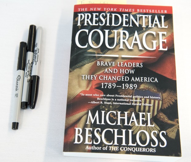 Eine weiße Fläche mit einem Buch namens "Presidential Courage: Brave Leaders and How They Changed America 1789-1989" von Michael Beschloss und zwei Stiften.