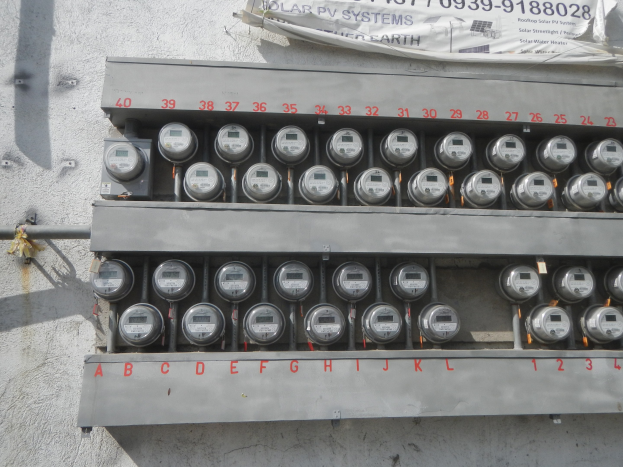 Nahaufnahme eines Elektrizitätszählers an der Seite eines Gebäudes mit einem Banner oben