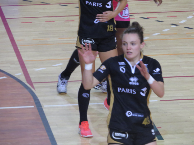 Eine Gruppe von Frauen in Sportuniformen beim Volleyballspielen auf einem Platz.