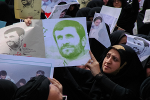 Eine Gruppe iranischer Frauen in schwarzer Kleidung, einige mit Brille, halten Bilder von Präsident Mahmoud Ahmadinejad während einer Demonstration in Teheran hoch.