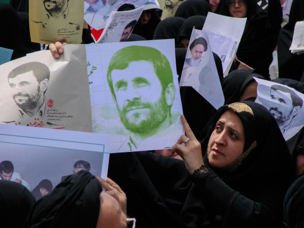 Eine Gruppe iranischer Frauen in schwarzer Kleidung, einige mit Brille, halten Bilder von Präsident Mahmoud Ahmadinejad während einer Demonstration in Teheran hoch.