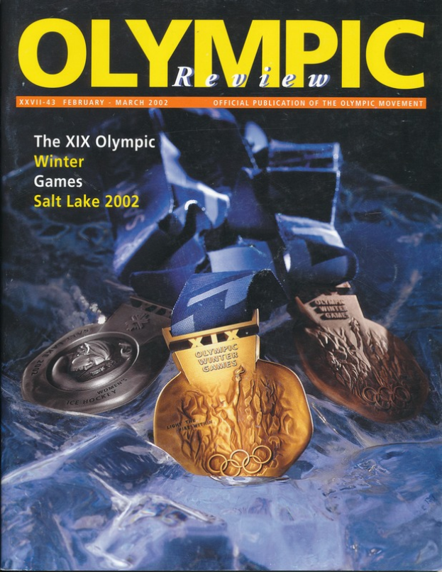 Ein Buch mit dem Titel "Olympische Spiele-Revue" mit mehreren Medaillen und fetter Schrift auf dem Cover.