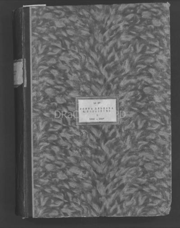 Schwarzes und weißes Foto eines geschlossenen Buches mit handgeschriebener Schrift auf dem Cover, das auf einem dunklen Hintergrund liegt.